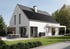 Modernes Einfamilienhaus mit Solarmodulen auf dem Dach, Wärmepumpe an der Seite und einer Terrasse mit Esstisch.