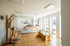 Moderner Empfangsbereich von LANDphysio mit Holztheke, Sprossenwand und hellen Trainingsgeräten in lichtdurchflutetem Raum.