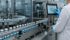 Pharmazeutische Fließbandproduktion mit Fläschchen; Wissenschaftler bedient ein Touchscreen-Kontrollpanel - Software-KRITIS Notfall- und Krisenmanager (NKM®).
