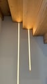 Holztreppe mit versteckter LED-Beleuchtung unter den Stufen und zwei vertikalen Lichtstreifen an der Wand.