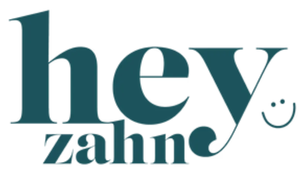 Dunkelgrüner Schriftzug „hey zahn“ auf schwarzem Hintergrund mit einem kleinen Smiley-Symbol neben dem Buchstaben y.
