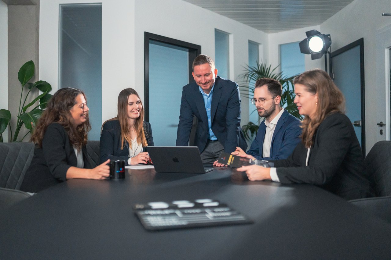 Skyrecords Team und Kunde besprechen gemeinsam die Kampagnenzahlen am Laptop