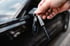 Hand mit weißem Handschuh poliert die rote Motorhaube eines Sportwagens.