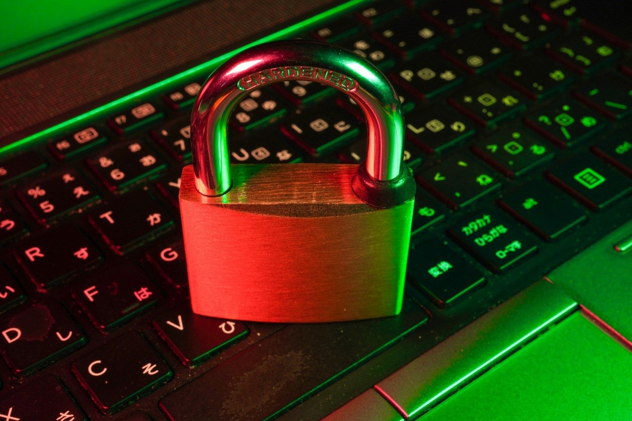 Rotes Vorhängeschloss auf einer beleuchteten Computertastatur
