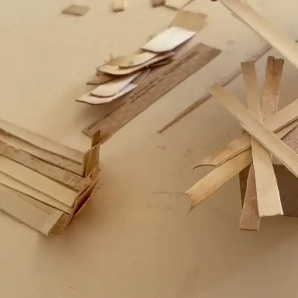 Hand legt Holzspäne übereinander