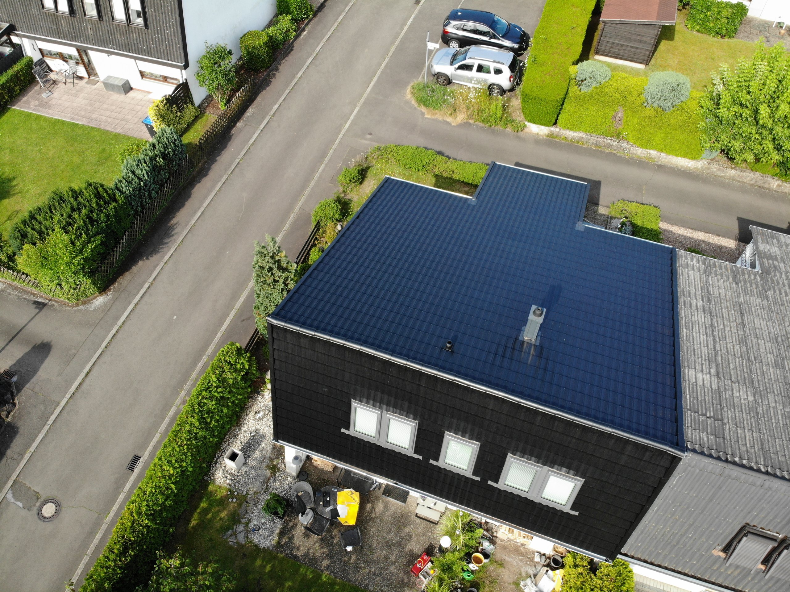 Handwerker beim Verlegen neuer Dachziegel auf einem Neubau