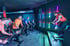 Indoor-Cycling-Kurs im Sportpark Laupheim mit Trainerin auf der Bühne und farbiger LED-Beleuchtung.