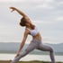 Woman doing yoga by a lake, illustrating neuropathy relief.