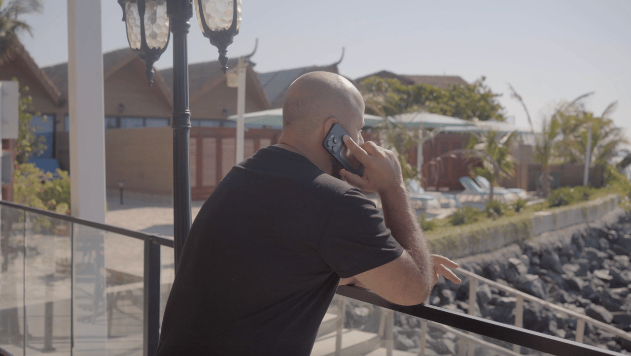 Ein Unternehmer telefoniert allein auf einem Balkon