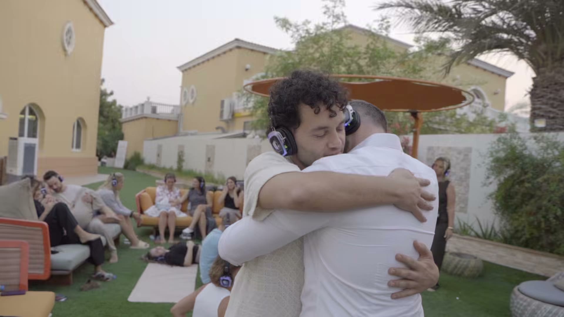Teilnehmer von Elevate & Connect umarmen sich im Garten der Villa