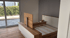 Unfertiges Bett aus Holz und weißem Lack in einem leeren Raum mit Glastür.