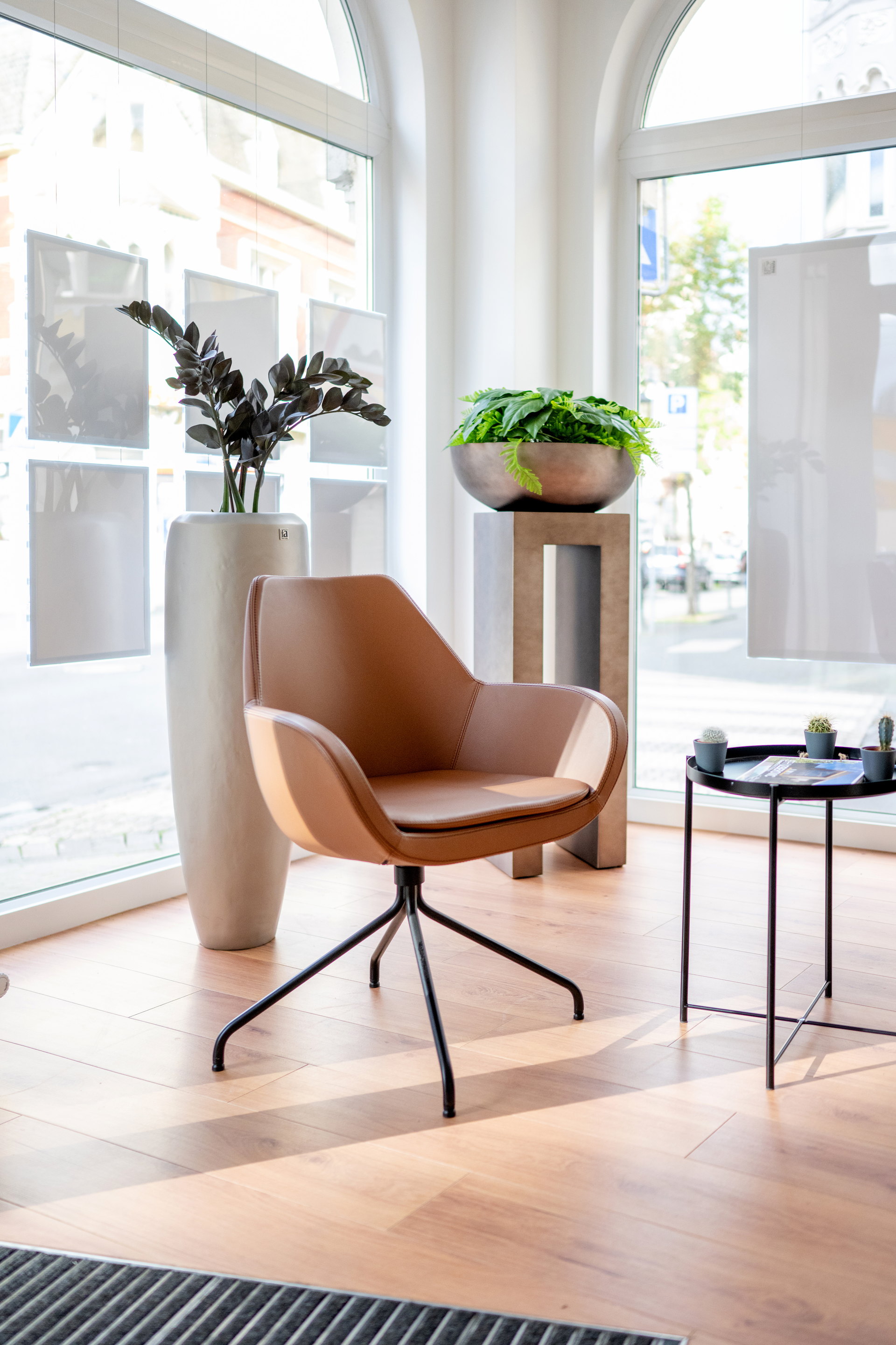 Heller Arbeitsplatz mit Tageslicht und drei Bildschirmen