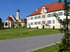 Rathaus mit Grünanlage und Kirchturm im Hintergrund