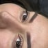 Nahaufnahme des Gesichts einer Frau mit perfekt geformten Augenbrauen und Wimpern, die nach oben schaut.