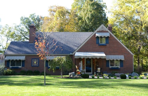 Backsteinhaus mit Rasen und Bäumen