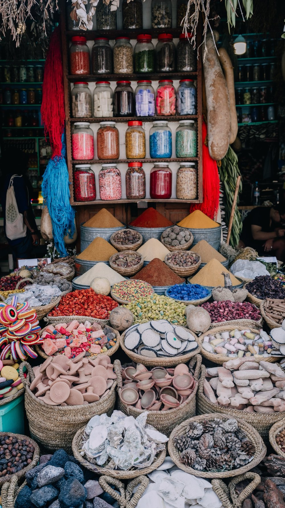 Marktstand mit Gewürzen, Gläsern und Körben in der Medina