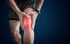 Person clutching knee, highlighting knee pain on dark background.