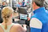 Trainer zeigt Frau Fitnessgerät mit Touchscreen im Fitnessstudio.