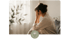 Woman with hands on her head, looking out a window, with a brain icon in a circle in the foreground.