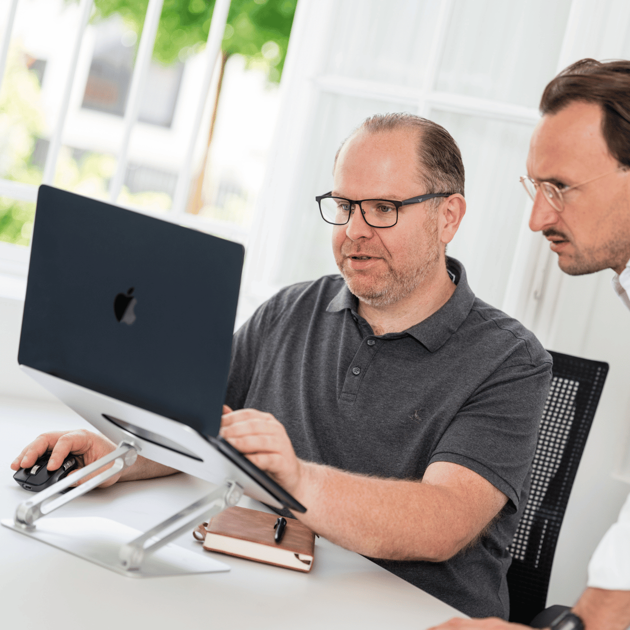 Florian Müller, Gründer und Geschäftsführer der ecom flow GmbH, im Kundentermin gemeinsam am Laptop im hellen Büro.
