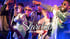 Männer in Sonnenbrillen und Anzügen singen auf der Bühne, ein Musiker spielt E-Gitarre. "STARCLUB LIVE - BÜHNE - BAR".