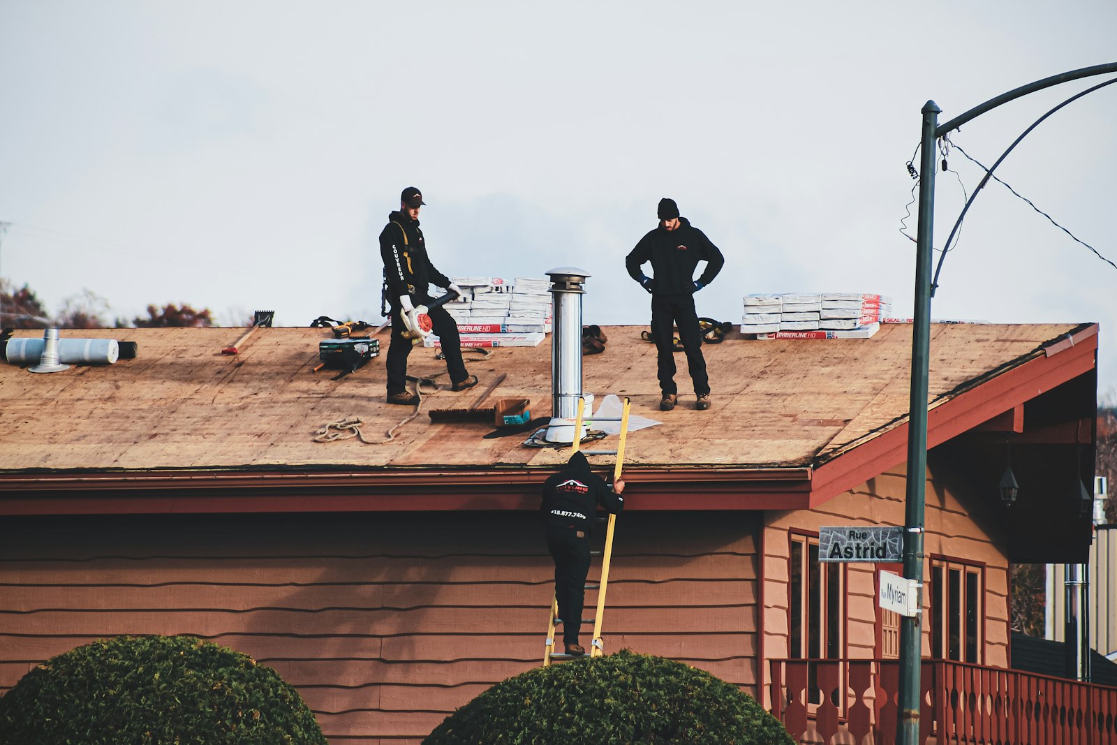 Roofers finishing a residential roof late in the day