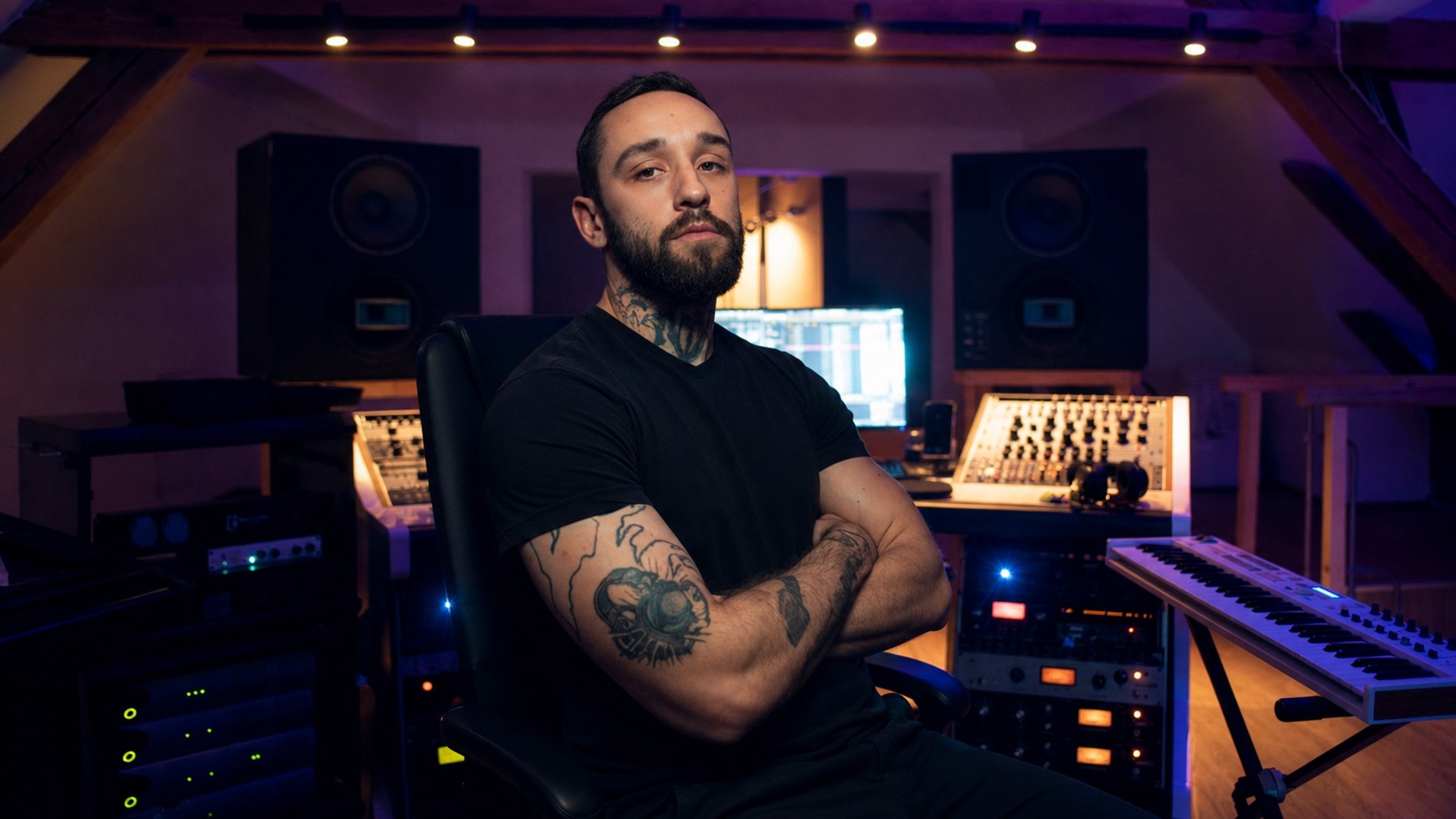 Gorex verschränkt die Arme vor seinem Studio-Equipment