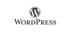 WordPress Logo: Ein graues "W" in einem Kreis über dem Wort "WordPress" auf grünem Hintergrund.