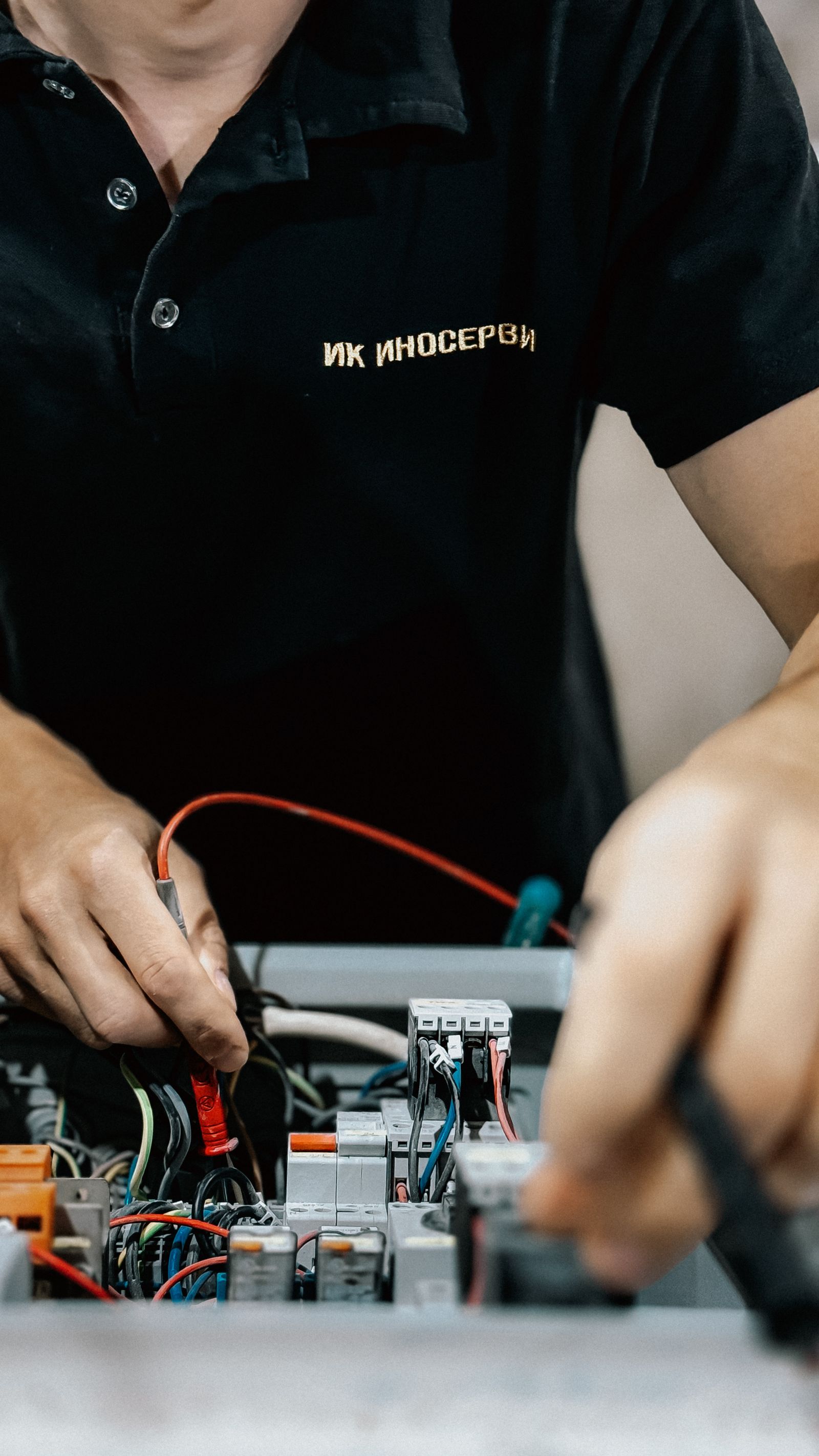 Technician working carefully on electrical components at a bench