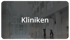 Zwei Personen in weißen Kitteln gehen durch ein modernes Krankenhausfoyer mit dem Schriftzug Kliniken.
