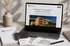 Laptop zeigt Webseite "Architektur-Fotografie in Villach und Kärnten", daneben Visitenkarten, Broschüre und Skizze.
