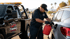 Towing Corona fuel delivery service refueling a stranded SUV to help the driver get back on the road.