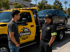 Towing Eastvale flatbed towing service driver assisting a customer before transporting a disabled sedan safely on a rollback truck