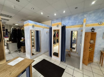 Verkaufsraum mit Umkleidekabinen und Kleidung an Kleiderstangen