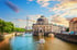 Bode-Museum und Berliner Fernsehturm an der Spree bei Sonnenuntergang mit Ausflugsbooten im Wasser.