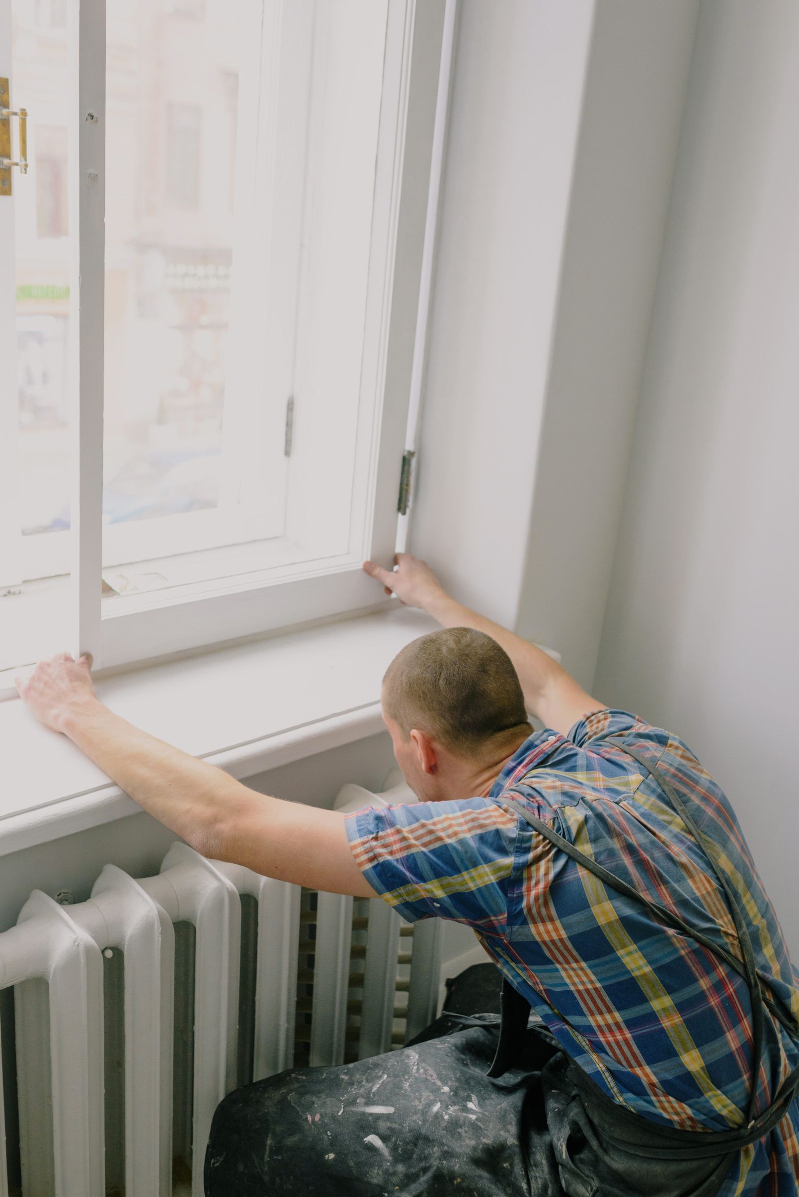 Installer fitting a replacement window frame into an opening