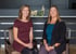 Two therapists holding pelvic models in clinic