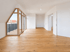 Leerer, heller Raum mit hellem Echtholzparkett, weißen Wänden und großer Fensterfront mit Zugang zum Balkon.