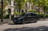 Schwarzer Mercedes-Benz V-Klasse Van parkt auf einer Straße vor Gebäuden mit Bäumen.