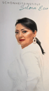 Selma Eser vom Schönheitsinstitut blickt in weißer Kleidung und mit Perlenschmuck in die Kamera.