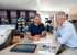 Zwei Männer besprechen Architekturpläne in einem modernen Showroom mit Whirlpool-Ausstellung und Katalogen.