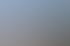 Drei Autos (weiß, rot, weiß) stehen vor einer weißen Autowerkstatt mit roten Toren unter blauem Himmel.