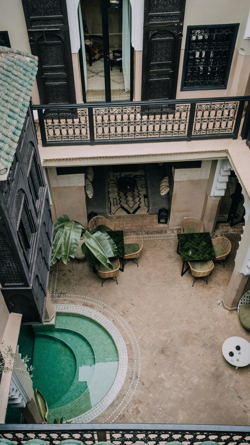 Blick von oben in den Innenhof eines Riads mit grünem Brunnen