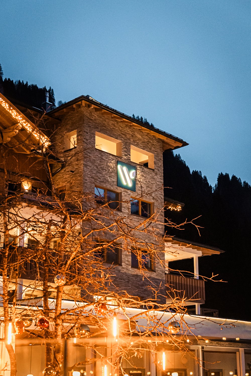 Hotel bei Nacht mit leuchtendem Logo