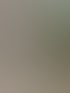 Arbeiter in orangefarbener Warnweste verlegt graue Pflastersteine in einem Fächermuster auf Sand.