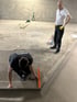 Zwei Männer bei der Arbeit: Einer kniet und benutzt eine Wasserwaage, der andere steht und beobachtet.
