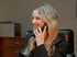 Lächelnde Frau mit blonden Haaren telefoniert im Büro.