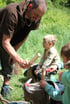 Kinder mit Stöcken spielend im Wald beim Wildnispädagogik Kurs im Landkreis Rosenheim und Chiemgau