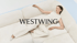 Eine Frau liegt auf einem weißen Sofa; der Text „WESTWING“ steht in der Mitte des Bildes.