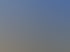 Ein Fensterputzer seilt sich an einer modernen grauen Bürogebäude-Fassade unter blauem Himmel ab.